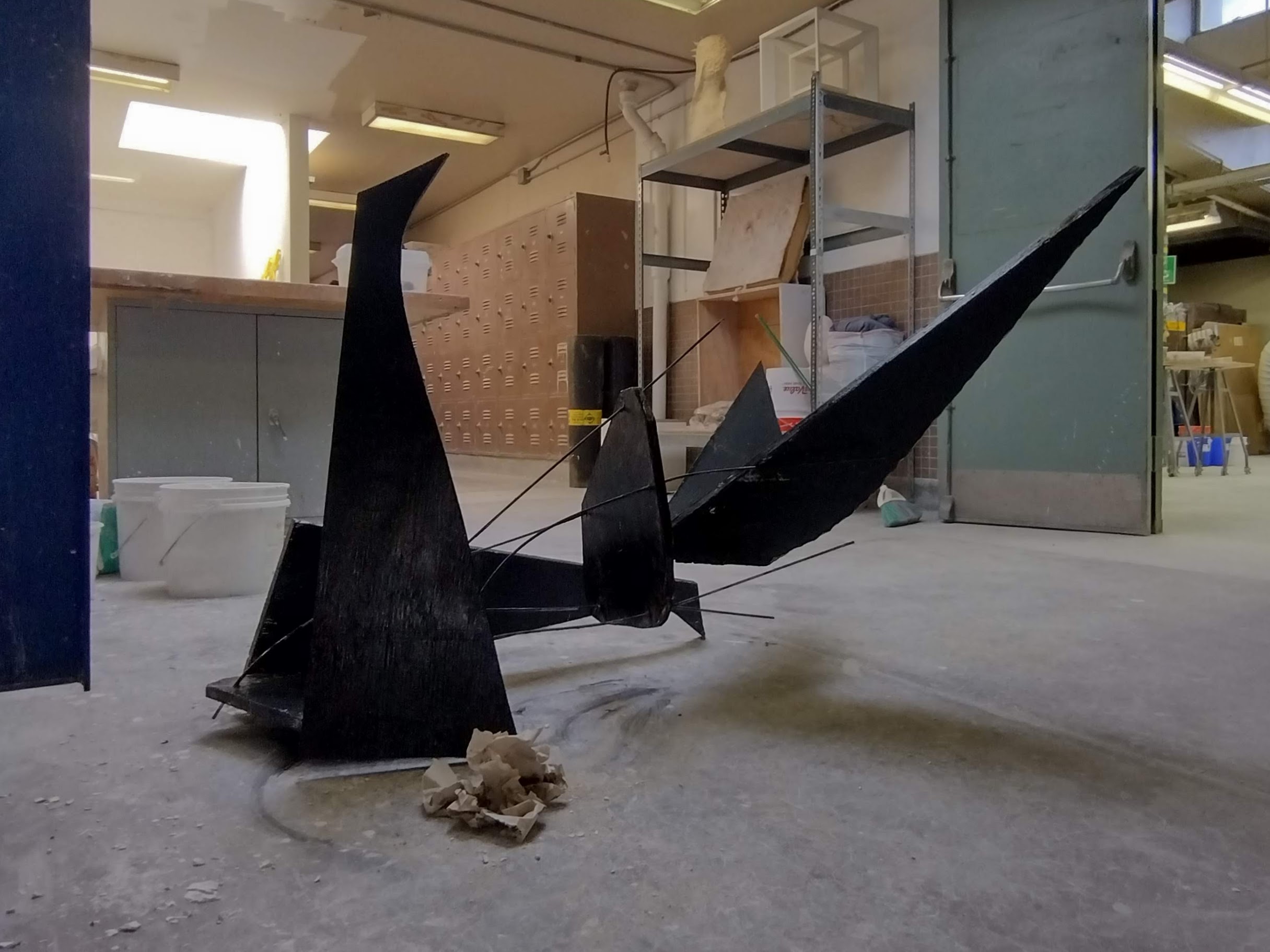 A toppled human of plywood and rebar